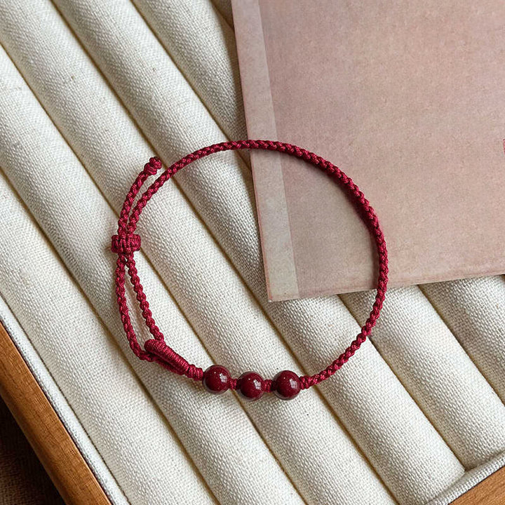 Buddha Stones Handgemaakte Armband van gevlochten touw met cinnaberkralen en een kalmerend effect. - image 2