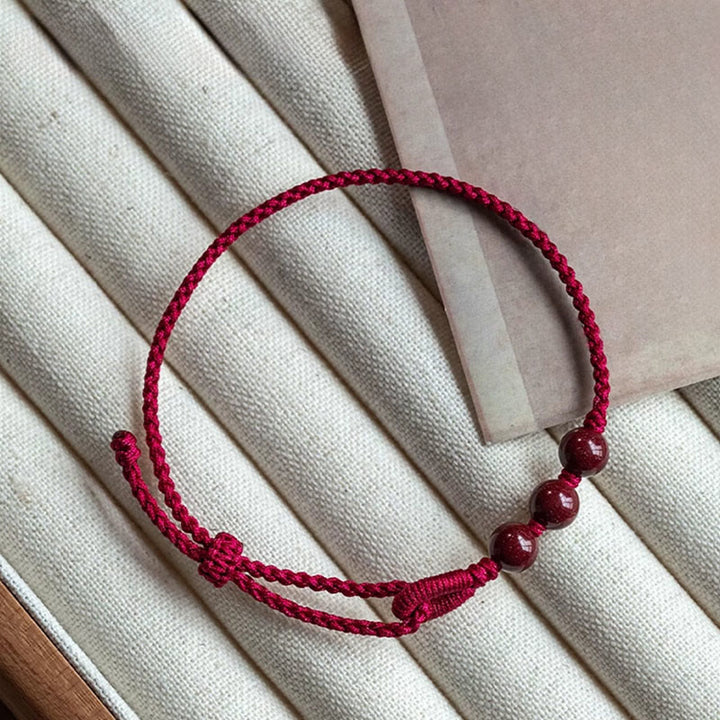 Buddha Stones Handgemaakte Armband van gevlochten touw met cinnaberkralen en een kalmerend effect. - image 1