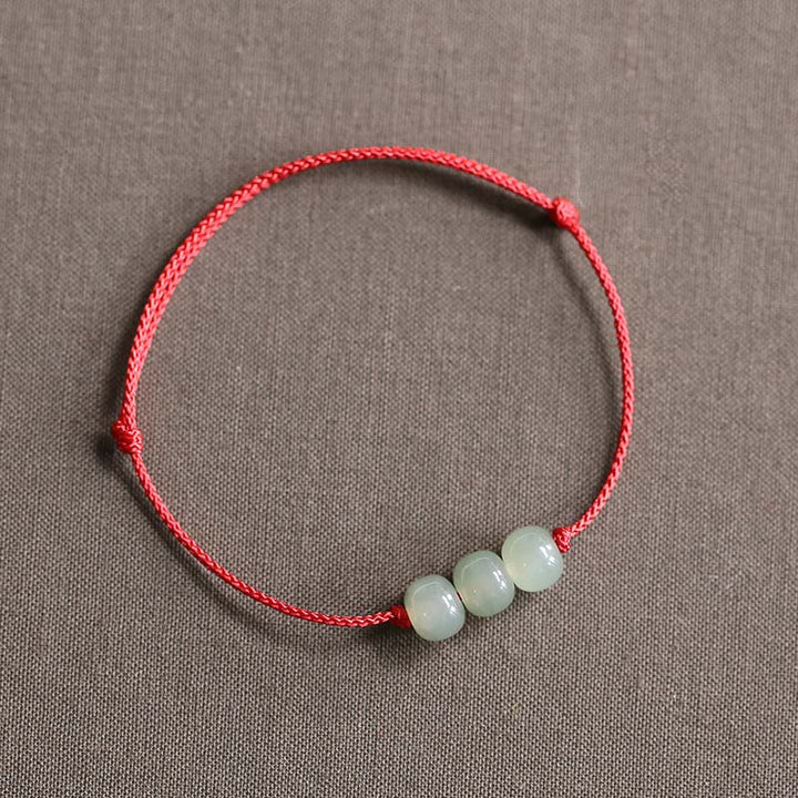 Buddha Stones Armband met drie jade kralen en gelukssymbool, geweven met een touwtje. - Rood (Polsomtrek 14-20 cm) - image 0